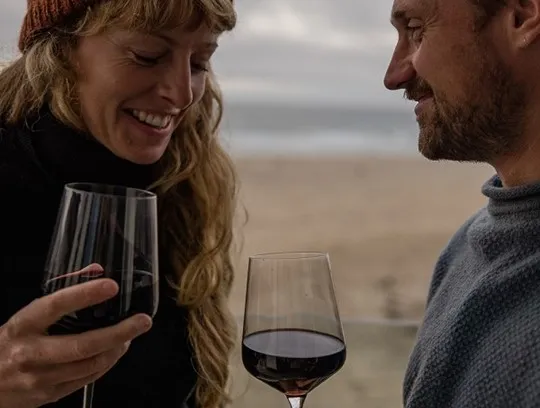 A couple holding wine glasses.