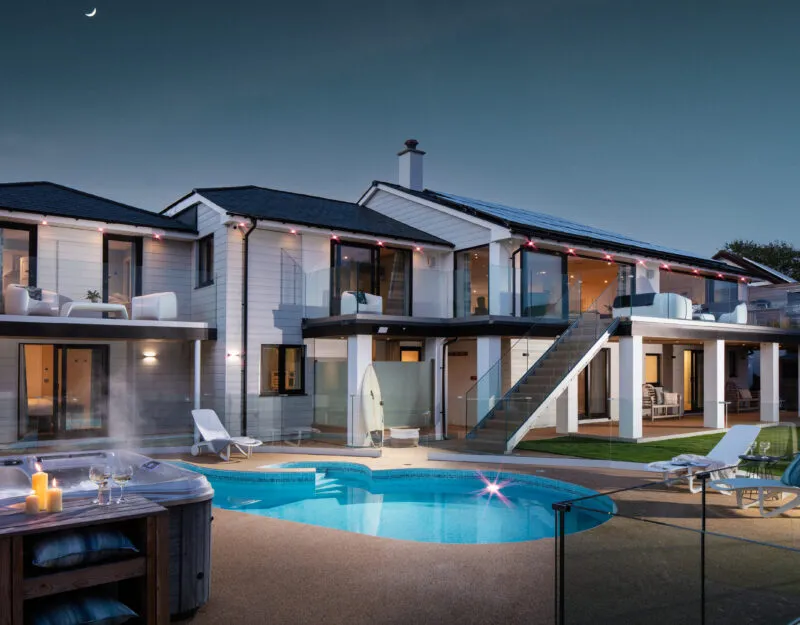Large house with swimming pool and hot tub at night