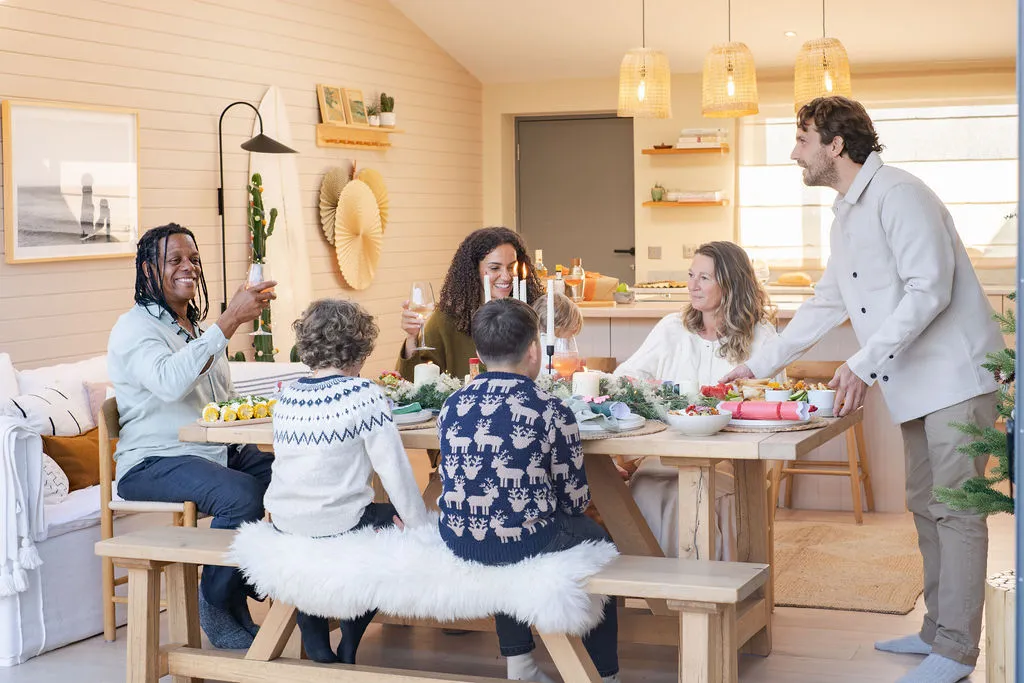 A family sit round a table enjoying Christmas dinner